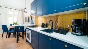耶莱尼亚古拉HELLO Apartamenty Evo - Długa 15的厨房配有蓝色橱柜、水槽和桌子