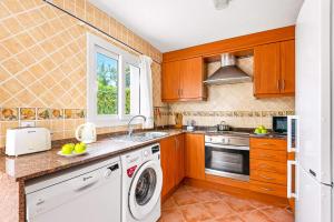 萨尔加Villa Beltran by Villa Plus的厨房配有木制橱柜、洗衣机和烘干机