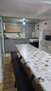 巴拉奈里奥-坎布里乌Hotel Paraná BC的厨房配有大白桌子和冰箱
