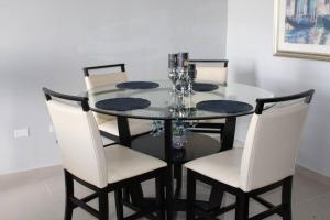 圣胡安Penthouse Views的餐桌、白色椅子和玻璃桌