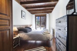 上阿兰Luderna - Apartamento Val de Ruda A10 Gerber的一间卧室配有带梳妆台和窗户的床。