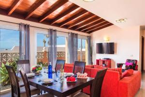 拉奥利瓦Villa Tamarindos by Villa Plus的一间带桌子和红色沙发的用餐室