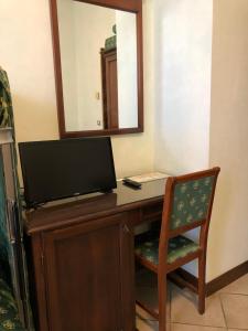 博尔塞纳佐迪亚科酒店的一张桌子,电视机和椅子放在房间里