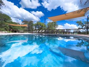 奥考奎约Ongava Lodge的一座蓝天云的游泳池