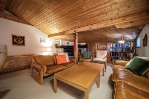 阿罗萨Casa Dschember, Wohnung 11, 1-6 Personen的客厅配有皮革家具和木制天花板