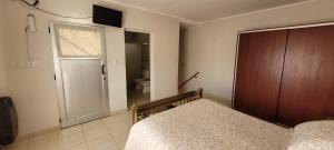 纳瓦罗Navarro Departamentos Temporarios的一间卧室配有一张床,一扇门通往浴室