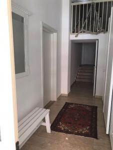 玛格丽塔萨沃亚Sopravento Apartments - Margherita di Savoia的走廊上设有长凳、地毯和楼梯