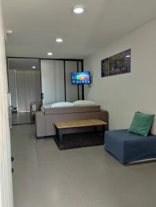 巴兰基亚Berilo Deluxe Apartahotel的客房设有床、沙发和电视。