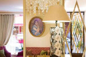 巴黎黎凡特酒店的一间用餐室,配有一盏灯和墙上的绘画