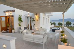 阿达玛斯Ostria Hotel 的配有白色家具的庭院,享有水景