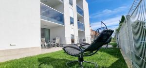 诺维格勒伊斯特拉A&V Residence的坐在建筑物前面的草上椅子