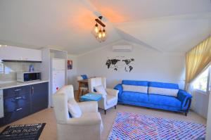 费特希耶Fethiye Sea View Suites的客厅配有蓝色的沙发和两把椅子