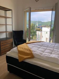 拉韦诺Ferienwohnung Laveno的卧室配有床、椅子和窗户。