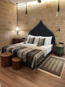 罗德镇Utopia Luxury Suites - Old Town的一间卧室设有一张大床和砖墙