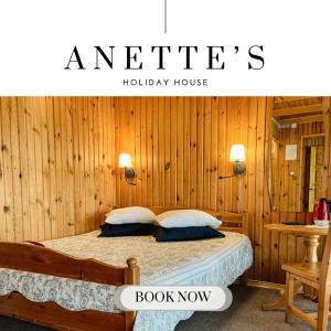 奥泰佩Anette's Holiday House的卧室配有木墙内的一张床