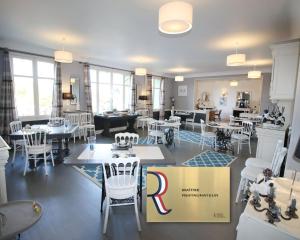 拉罗什波赛Logis Hôtel & Restaurant Au Clos Paillé Charme & Caractère的一间设有白色桌椅和盒子的餐厅