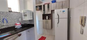 戈亚尼亚Apartamento Mobiliado, Parque Atheneu.的厨房配有白色冰箱和电话
