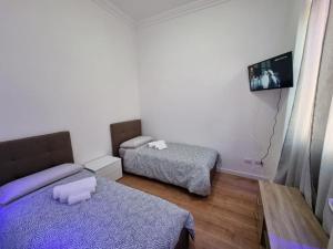 圣雷莫Piazza Colombo-Apartments的小房间设有两张床和电视