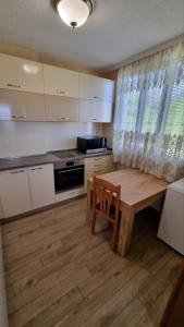 ChalaРодопска къща за гости с.ЧАЛА的厨房铺有木地板,配有木桌。