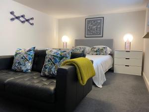 大雅茅斯Jays Bay Entire Luxury Apartment by the Beach Gt Yarmouth的一间卧室配有沙发和一张带两盏灯的床。