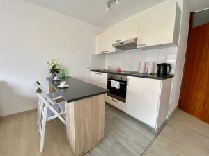 伯布林根Exklusiv, modernes Apartment mit Balkon的厨房配有白色橱柜和黑色台面