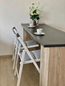 伯布林根Exklusiv, modernes Apartment mit Balkon的黑白桌子和椅子,两杯