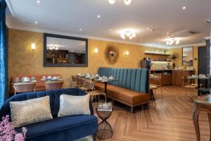 巴黎皇家圣日耳曼酒店的一间设有蓝色沙发的餐厅和一间用餐室