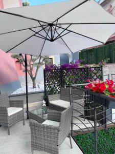 维耶特里Aretusa Resort Amalfi Coast的庭院配有遮阳伞、椅子和鲜花桌。