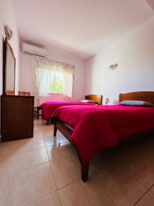 圣巴巴拉-迪内希Vila Flora的宿舍间的两张床,配有红色床单和窗户