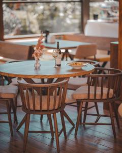 苏利纳Delta Est Hotel & Restaurant的一张带椅子的木桌和一张带饮料的桌子