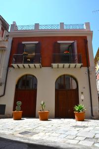 巴勒莫Isula的一座房子,前面有三扇门和盆栽植物