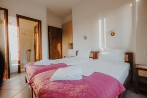 MakrirrákhiHouse of Gardenia的一间卧室配有两张带粉色和白色床单的床