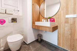 梅尔诺VacationClub – Jantaris Apartament A8的浴室设有白色的卫生间和镜子