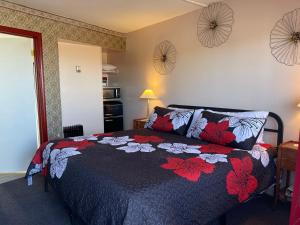 弗吉尼亚城舒格洛夫山汽车旅馆的一间卧室配有一张带黑色和红色毯子的床
