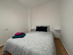 托洛克斯Apartamentos Los Senderos de Tolox的一间卧室配有一张带黑白色棉被的床