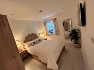 温莎Windsor, LEGOLAND, Ascot & Windsor RACECOURSE sleeps 3的一间卧室配有一张床、两盏灯和一面镜子