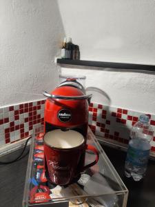 圣雷莫ROSEROSSE casa vacanze的一张桌子上的一个红色咖啡壶