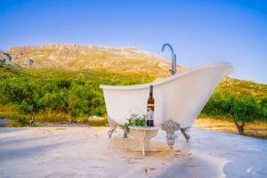 阿吉亚帕拉斯夫Bungalows Panstel in Kerames Rethymno的白色浴缸,配有一瓶葡萄酒和一杯