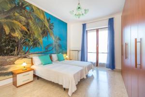 都灵MERCADANTE FAMILY APARTMENT的一间卧室配有床和棕榈树壁画