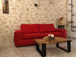 蒙泰圣比亚焦Alloggio per turisti a solo 10 minuti dal mare的客厅里一张红色的沙发,配有茶几