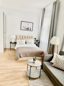 里加Suites by Riga Old Town的一间卧室配有一张床、一张沙发和一张桌子