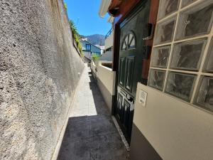 丰沙尔Casa Alegria的两座建筑之间的一条小巷,有一道黑色的门
