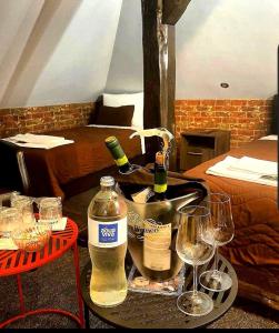 皮罗特Hotel style rooms & restaurant Pirocanac的一张桌子,上面放有两杯酒和瓶装葡萄酒