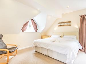 Great WitcombeBeeches Studio的卧室配有白色的床和椅子