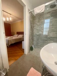 Borgofranco dʼIvreaBed and Breakfast L'Albero Maestro的带淋浴和盥洗盆的浴室以及一间卧室