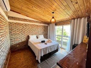 弗雷谢拉斯Villa Flecheiras的一间卧室设有一张床和砖墙