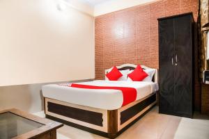 巴特那Flagship Hotel Embassy Exhibition Rd的一间卧室配有一张带红色枕头的大床