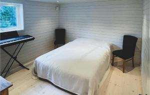 Kåröd2 Bedroom Gorgeous Home In Stillingsn的一间卧室配有一张床、一张书桌和一个键盘