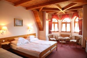 豪伊杜索博斯洛豪伊杜城堡酒店的卧室配有一张床和一张桌子及椅子