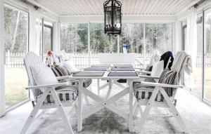 卡尔斯塔德4 Bedroom Nice Home In Karlstad的白色的用餐室配有白色的桌椅